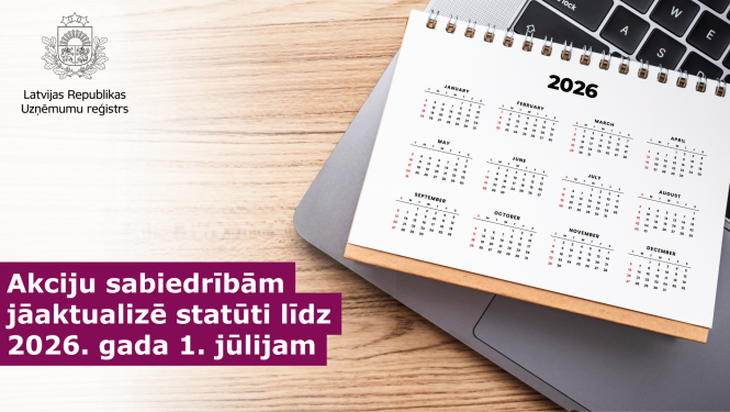 Uz galda portatīvais dators uz kura novietots kalendārs ar 2026.gada jūliju
