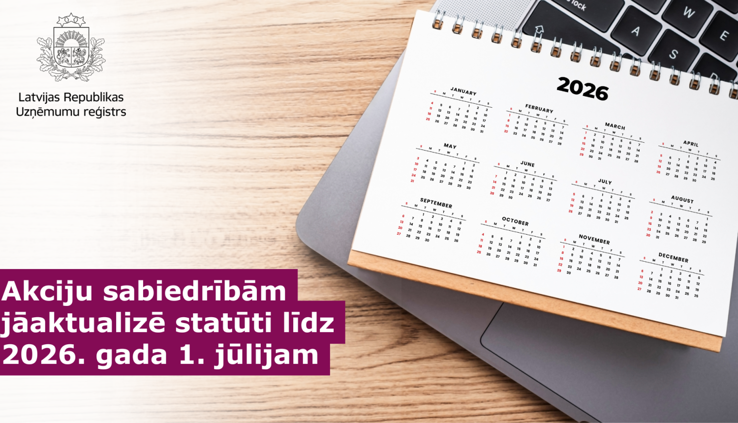 Uz galda portatīvais dators uz kura novietots kalendārs ar 2026.gada jūliju