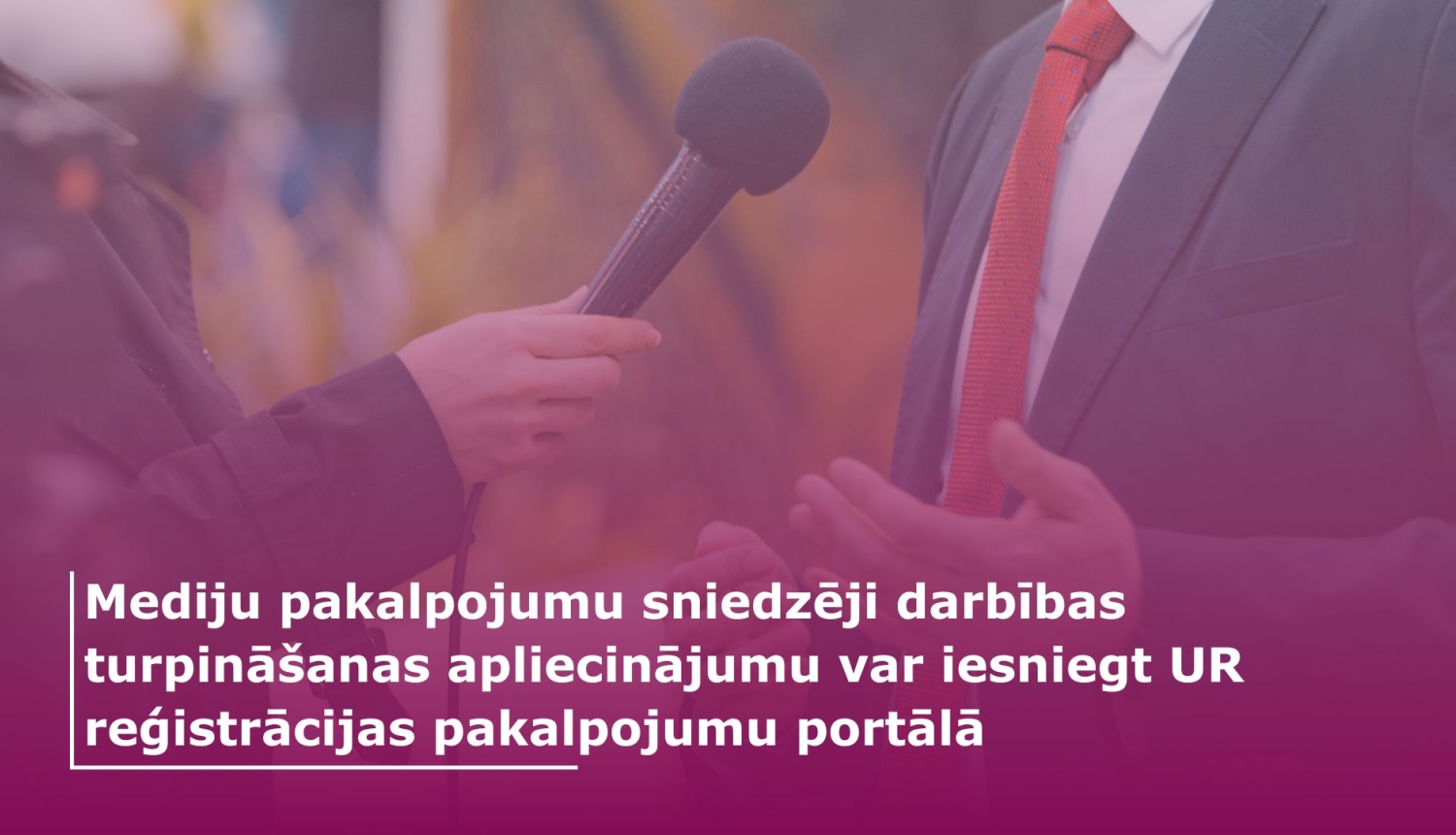 Žurnālists tur rokā mikrofonu un intervē personu